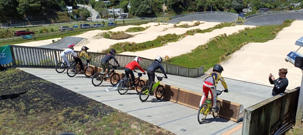 Image of junior riders lined up on the gate, with coach taking video for technique analysis.